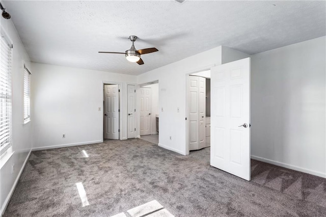 unfurnished bedroom featuring a ceiling fan, carpet, baseboards, and a textured ceiling