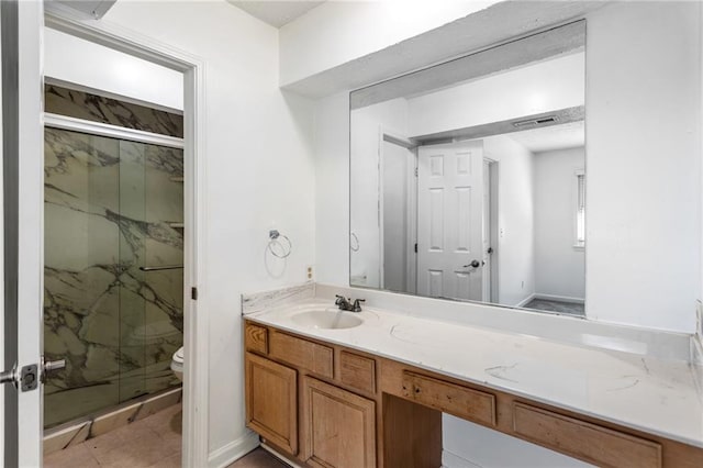 bathroom with vanity, toilet, visible vents, and a marble finish shower