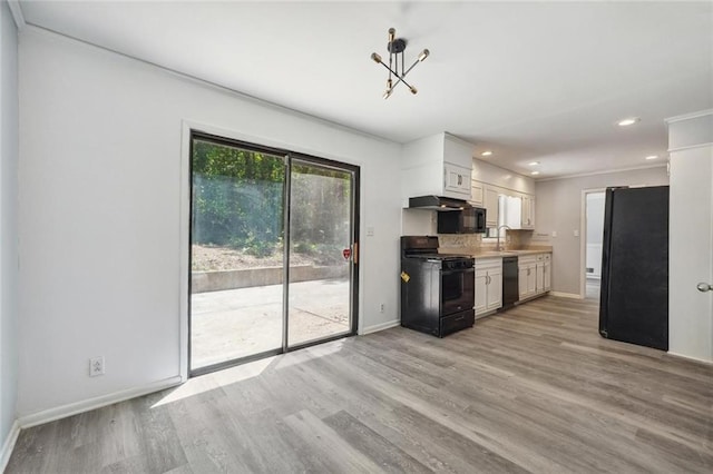 kitchen with ornamental molding, black appliances, an inviting chandelier, light hardwood / wood-style floors, and white cabinetry