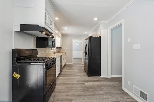 kitchen featuring crown molding, sink, black appliances, light hardwood / wood-style flooring, and white cabinets