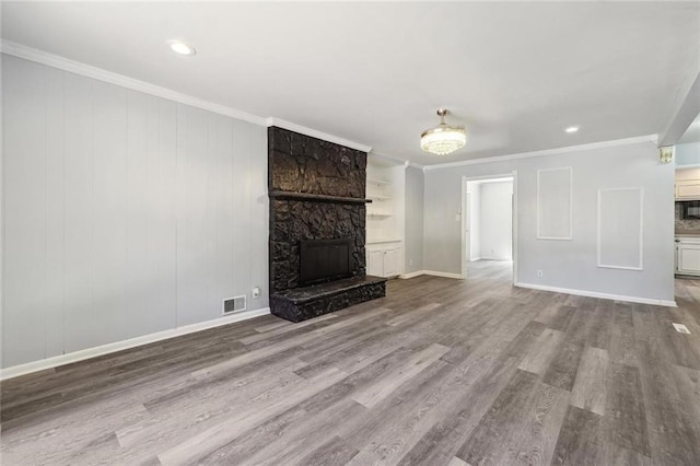 unfurnished living room with light hardwood / wood-style flooring, a stone fireplace, and crown molding