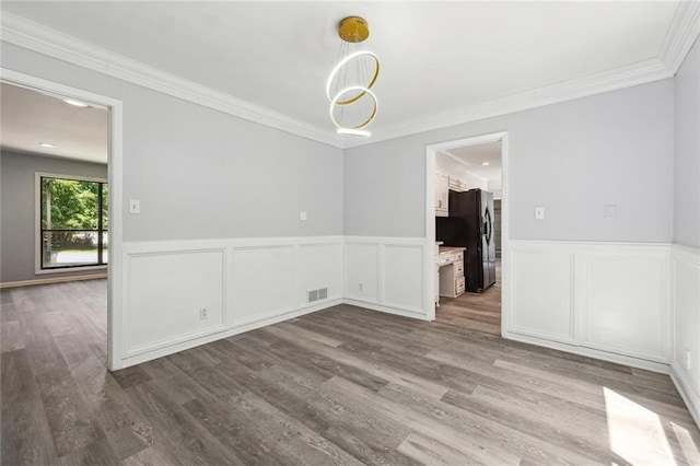 unfurnished dining area featuring crown molding and light wood-type flooring