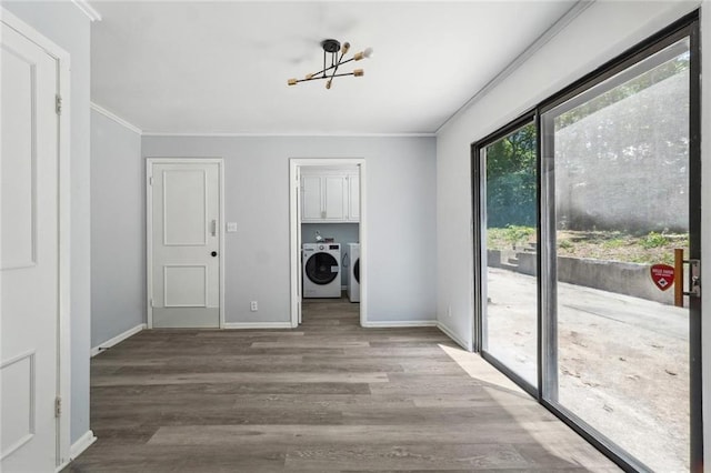 laundry room featuring cabinets, separate washer and dryer, ornamental molding, a notable chandelier, and light hardwood / wood-style floors