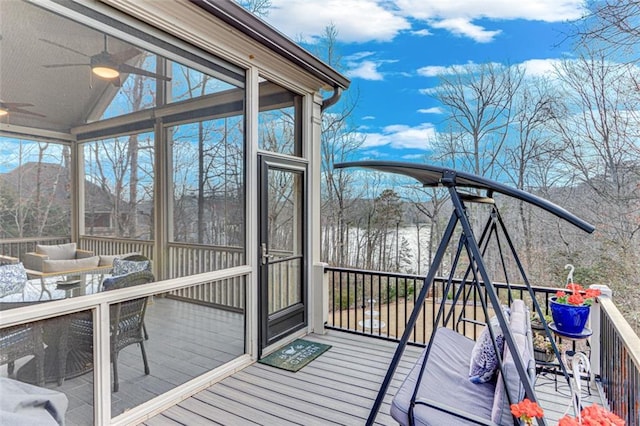 wooden terrace with a sunroom and ceiling fan