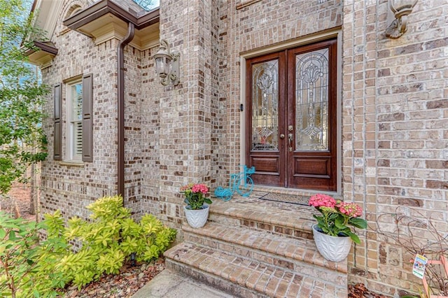 doorway to property featuring french doors and brick siding