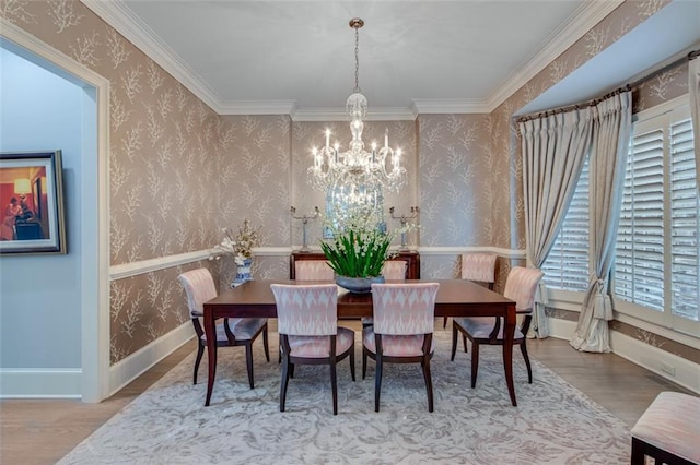 dining space with ornamental molding, a notable chandelier, wood finished floors, and wallpapered walls