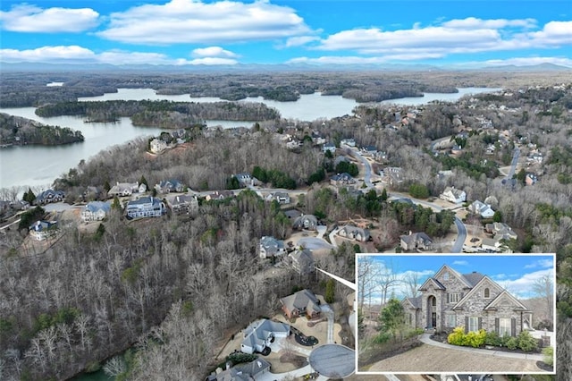drone / aerial view featuring a wooded view and a water view