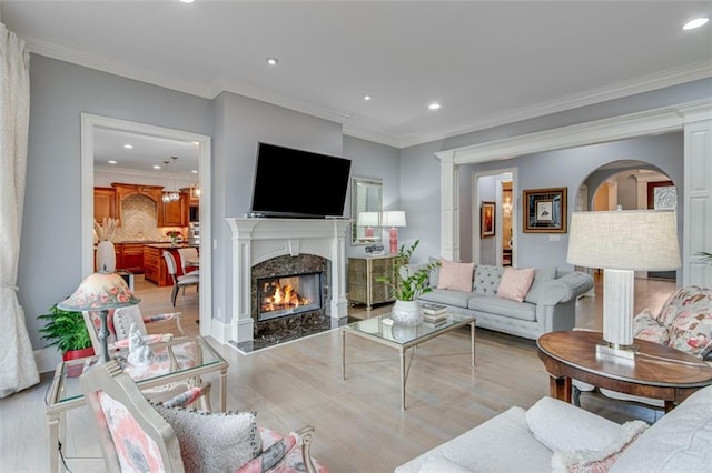 living area with a premium fireplace, wood finished floors, and recessed lighting