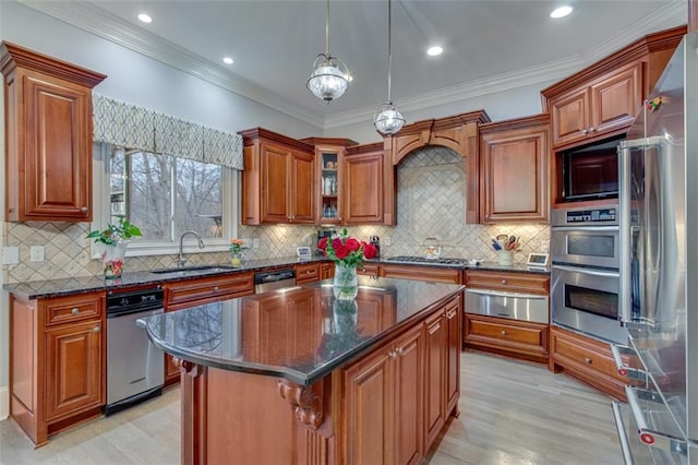 kitchen with stainless steel appliances, light wood-style flooring, a sink, a warming drawer, and brown cabinetry