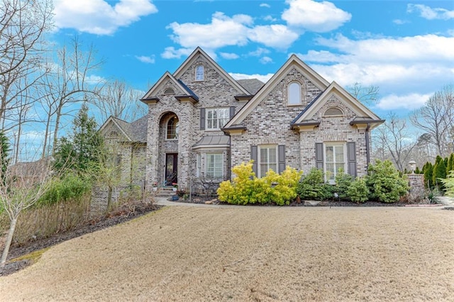 french provincial home featuring brick siding