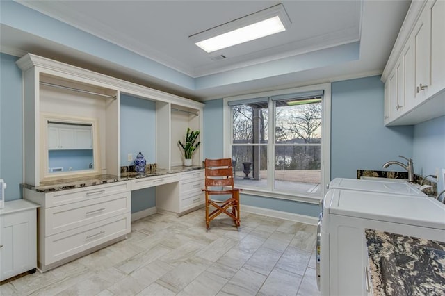clothes washing area with crown molding, a sink, cabinet space, and washer / dryer
