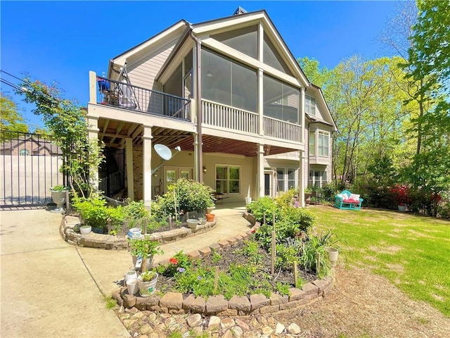 rear view of property with a patio area, a sunroom, and a yard