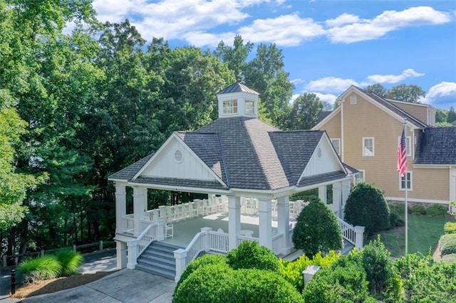 view of front of property with a gazebo and roof with shingles