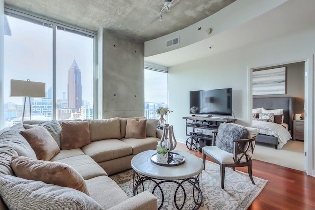 living room featuring a wall of windows and dark wood-type flooring