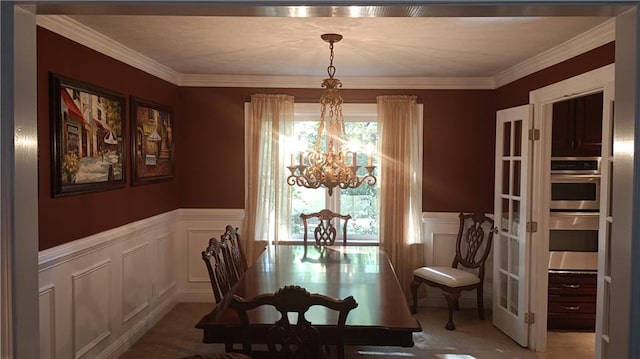 dining space with light colored carpet, a chandelier, and ornamental molding