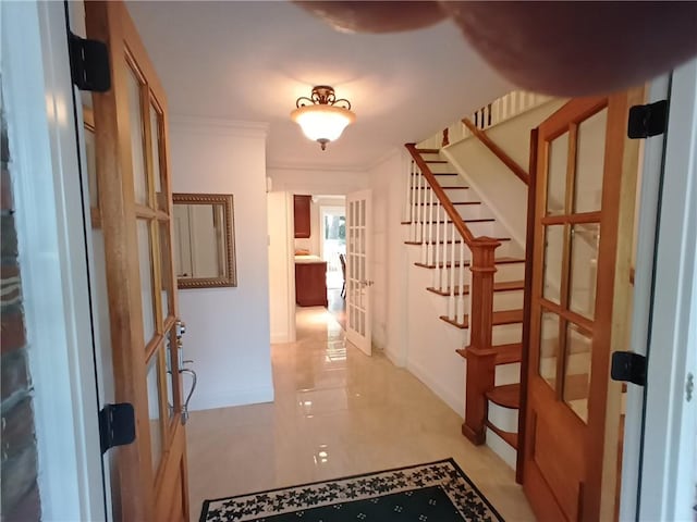 hall with light tile patterned flooring and ornamental molding