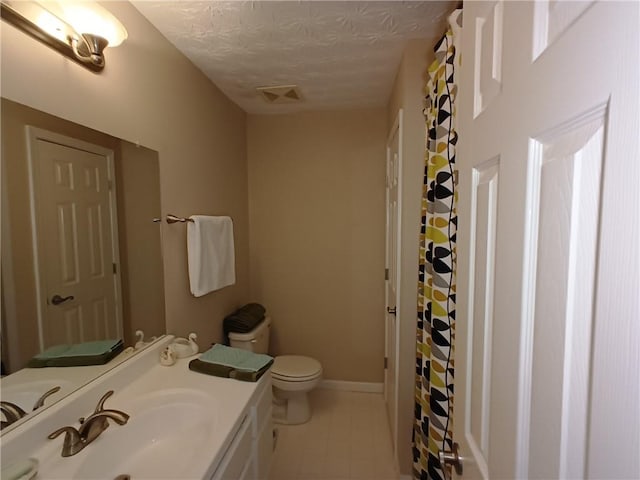 bathroom featuring vanity, a textured ceiling, and toilet