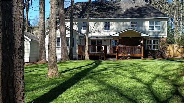 rear view of house with a lawn and a wooden deck