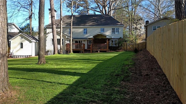 rear view of property with a yard and a deck