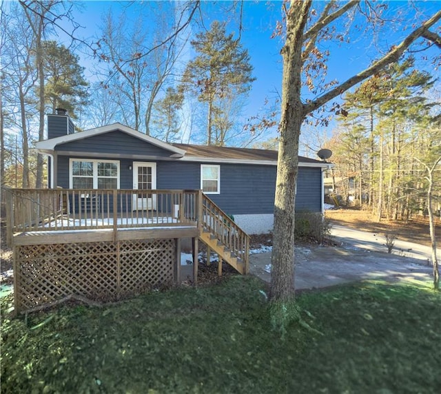 rear view of property featuring a yard and a deck