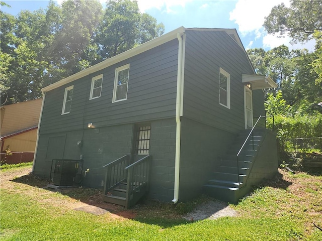 back of property featuring a yard and central air condition unit