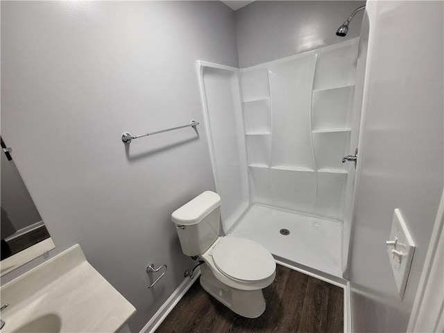 bathroom featuring hardwood / wood-style floors, walk in shower, toilet, and vanity