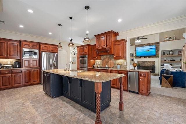 kitchen with a sink, stainless steel appliances, open floor plan, and ornamental molding