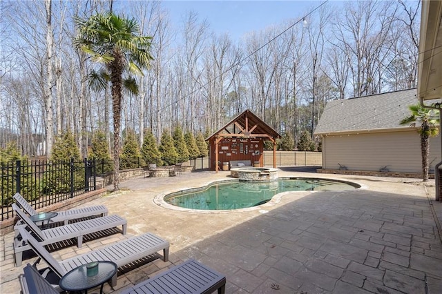 view of pool featuring a patio, an outdoor structure, fence, and a pool with connected hot tub