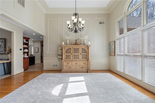 dining area with visible vents, a notable chandelier, and wood finished floors