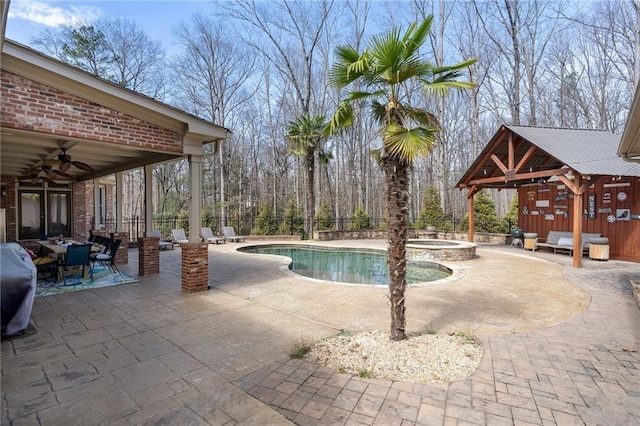 view of swimming pool with a ceiling fan, a patio, fence, a fenced in pool, and an in ground hot tub