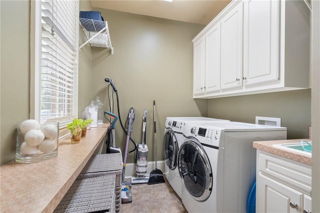 washroom with washer and clothes dryer, cabinet space, and baseboards