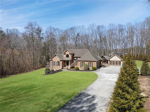 view of front of house with a wooded view, an attached garage, concrete driveway, and a front lawn