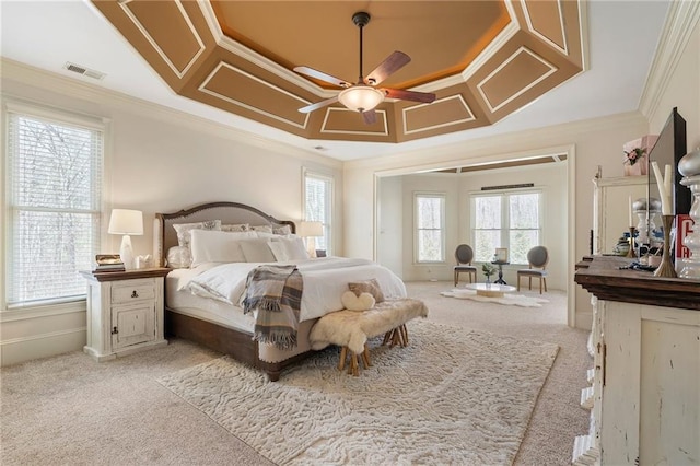 bedroom with visible vents, multiple windows, a raised ceiling, and crown molding