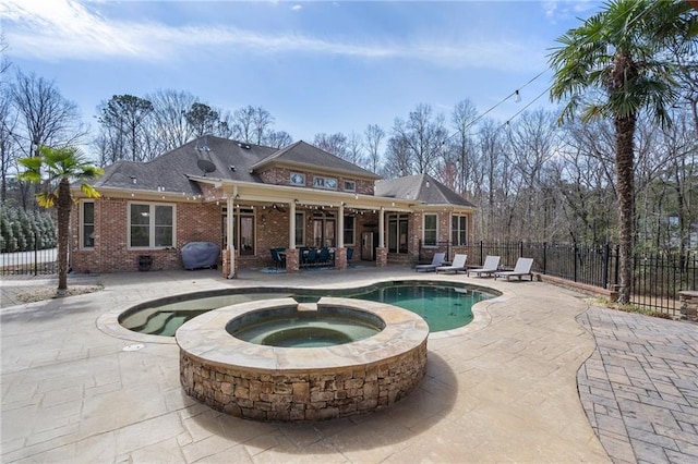 view of pool with a patio, area for grilling, fence, and a pool with connected hot tub