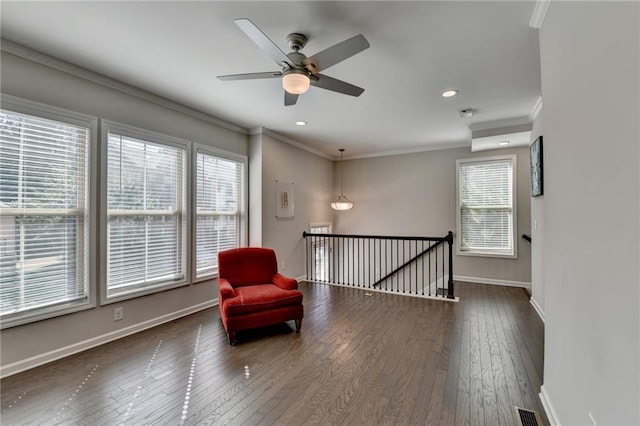 unfurnished room with baseboards, visible vents, dark wood-style floors, ornamental molding, and an upstairs landing