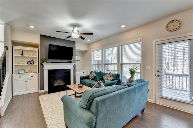 living area featuring dark wood-style flooring, a fireplace with flush hearth, a ceiling fan, and recessed lighting