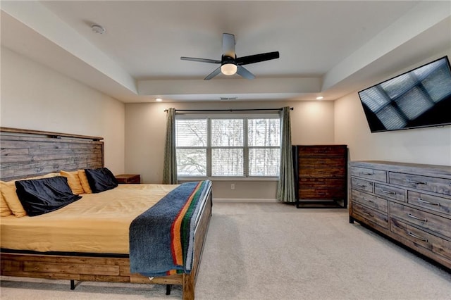 bedroom with a tray ceiling, recessed lighting, light colored carpet, a ceiling fan, and baseboards