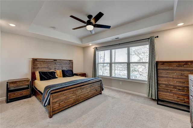 bedroom featuring light carpet, baseboards, visible vents, a raised ceiling, and recessed lighting