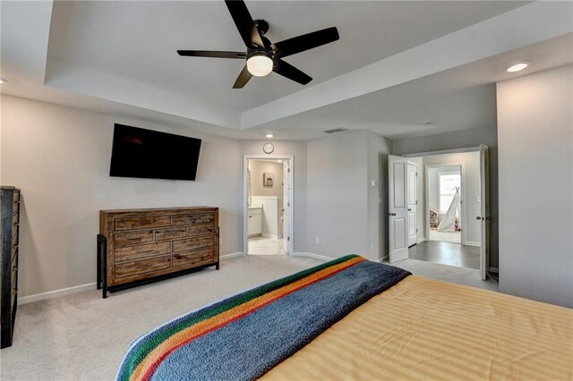 bedroom with a tray ceiling, carpet flooring, and baseboards