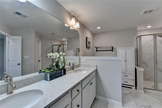 bathroom featuring marble finish floor, a marble finish shower, visible vents, and a sink