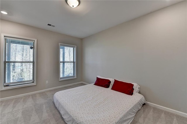 carpeted bedroom featuring visible vents and baseboards