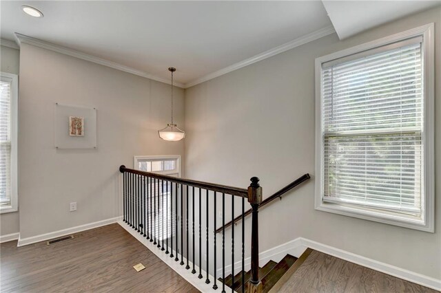 staircase featuring baseboards, wood finished floors, and ornamental molding