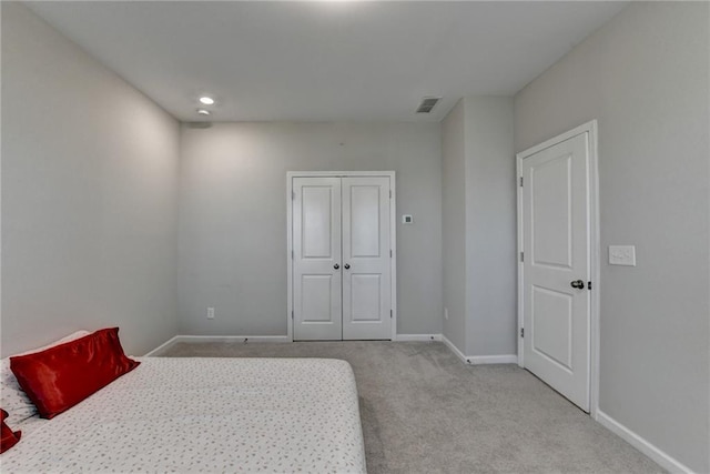 bedroom featuring carpet floors, baseboards, visible vents, and a closet