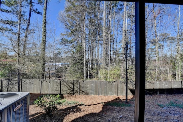 view of yard with a fenced backyard and central AC unit