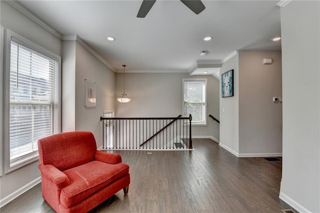 living area with plenty of natural light, baseboards, dark wood-style floors, crown molding, and an upstairs landing