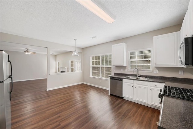 kitchen featuring sink, white cabinets, hanging light fixtures, stainless steel appliances, and dark hardwood / wood-style flooring