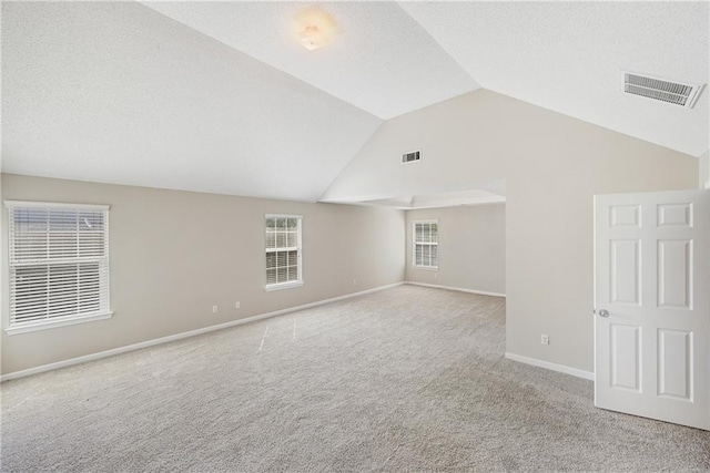 unfurnished room featuring vaulted ceiling and light colored carpet