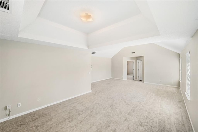 unfurnished room with light colored carpet and a raised ceiling