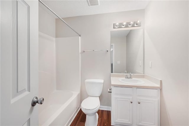 full bathroom with shower / washtub combination, vanity, a textured ceiling, wood-type flooring, and toilet