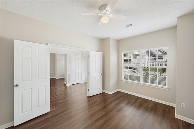 spare room featuring a textured ceiling, dark hardwood / wood-style flooring, and ceiling fan